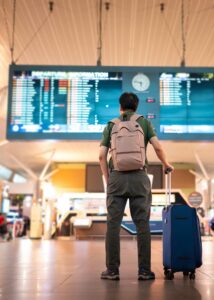 Traveler with suitcase looking are flight departure board